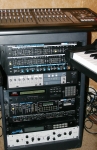Rack top to bottom: TASCAM US-2400 24-fader controller, Roland Super Jupiter Programmer, TASCAM FW-1804 audio/MIDI interface, Yamaha TX-802, Roland Super Jupiter, Alesis 3630 compressor, Alesis MidiVerb 4 prototype, Lounge Audio solid-state Pultec EQ